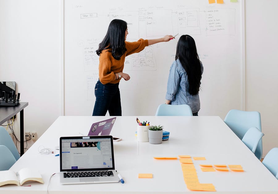 chicas haciendo brainstorming en su puesto de trabajo