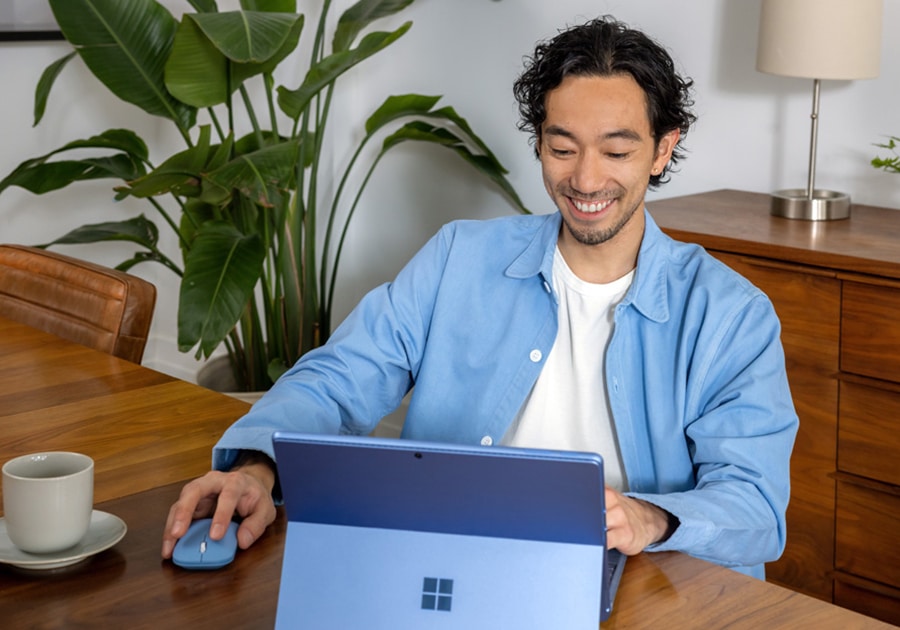 hombre sonriendo mientras utiliza un ordenador portátil
