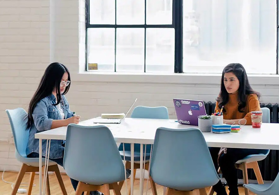 dos chicas colaborando en su workplace